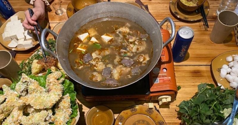Một nồi lẩu cá tầm hoặc lẩu cá lăng đầy đủ rau, bún