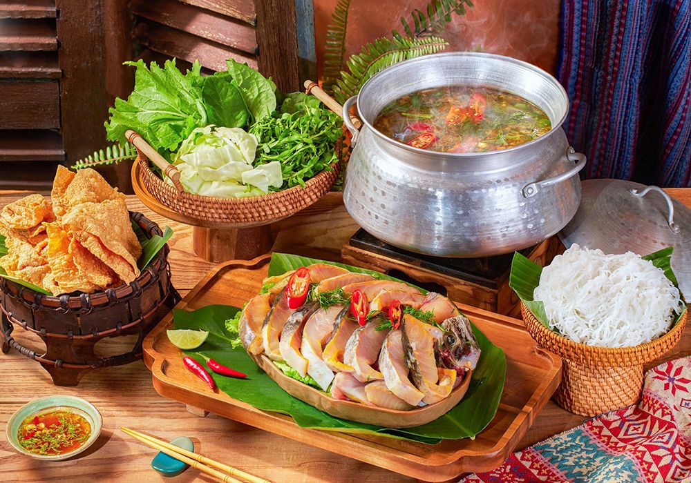 Lẩu cá tầm Sapa với thịt cá chắc thơm, nước dùng chua cay, ăn kèm cải mèo và su su vùng cao.